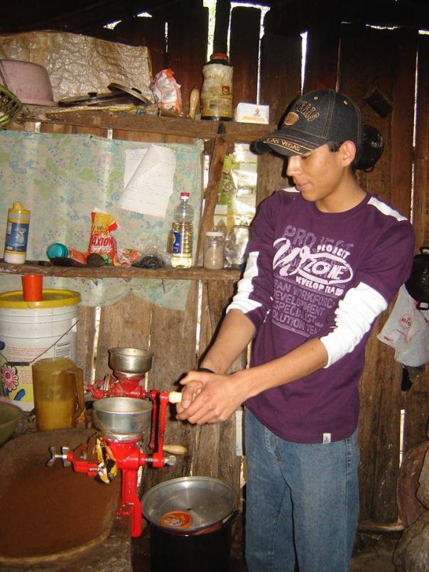 A Mission Volunteer tries out the coffee grinder 