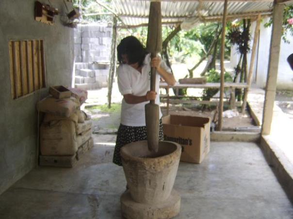 The first step in grinding the coffee beans.  The wooden mortar and pestle resembles the essential tool used in Africa and worldwide.