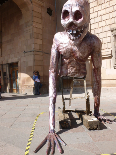 The couple embracing in the background of this photo might represent those of us so far from the migrants’ experience./La pareja que se abraza en el fondo de esta foto puede ilustrar a  nosotros  tan alejados de la experiencia de los migrantes. 